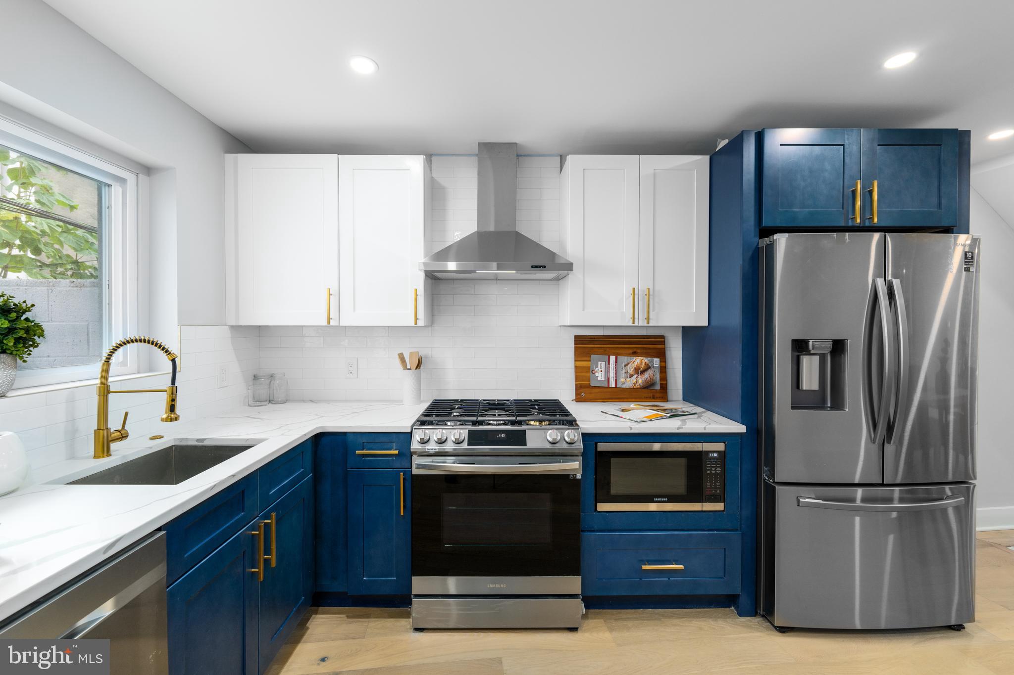 a kitchen with kitchen island granite countertop a refrigerator and a stove top oven