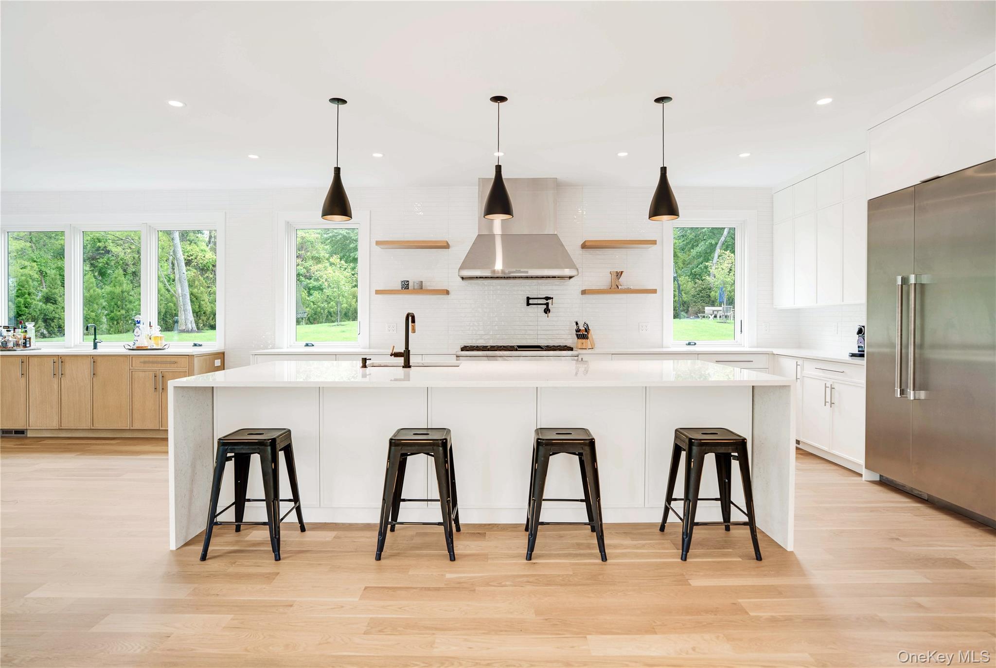 100 South Ferry Road Shelter Island, NY 11964 - Photo 11 of 28 a dining table with chairs a wooden floor and a floor to ceiling window