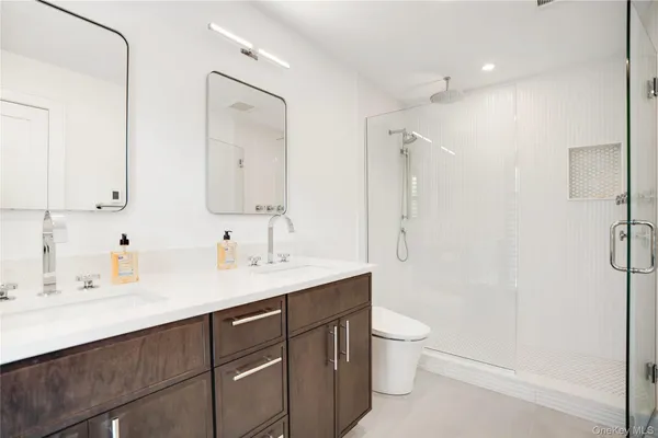 a bathroom with a sink a toilet and shower