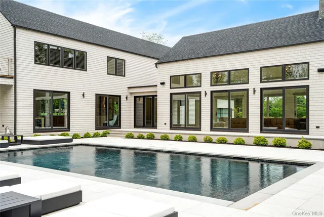 a swimming pool with outdoor seating and yard