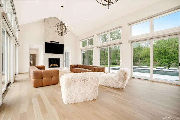 a living room with furniture a large window and a fireplace