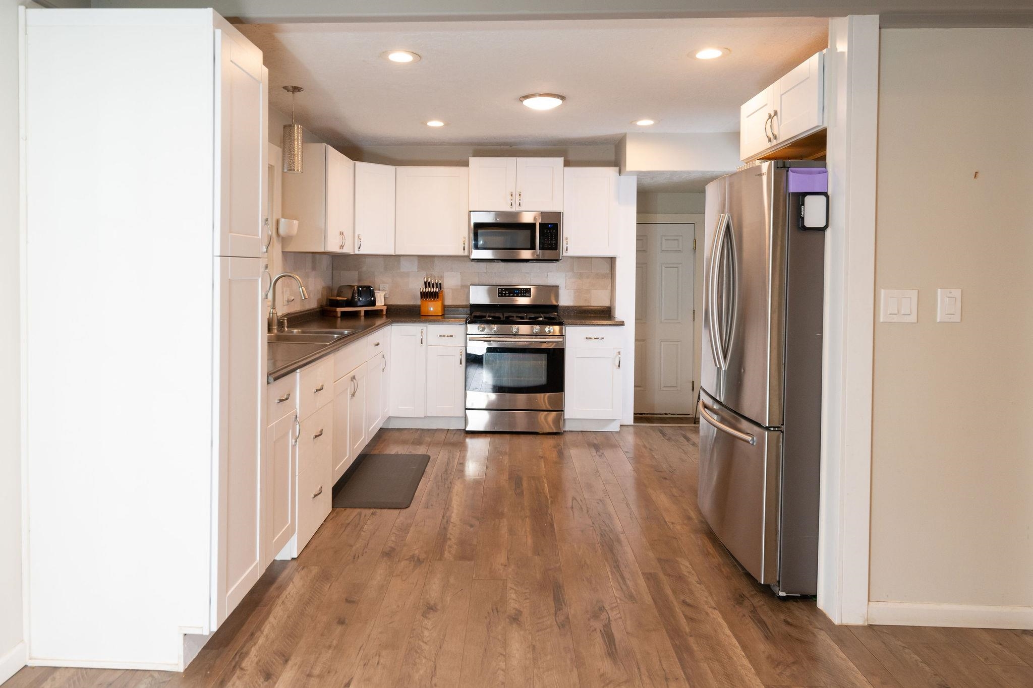4743 Welsh Road Rockford, IL 61107 - Photo 18 of 52 a kitchen with stainless steel appliances granite countertop a refrigerator a sink dishwasher a stove and white countertops with wooden floor