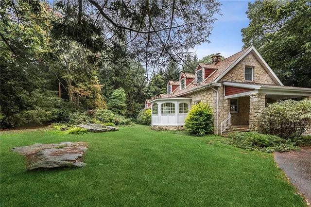 a front view of a house with a yard and trees