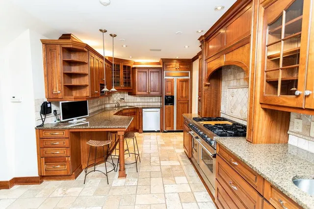 a kitchen with stainless steel appliances granite countertop a stove and a wooden cabinets