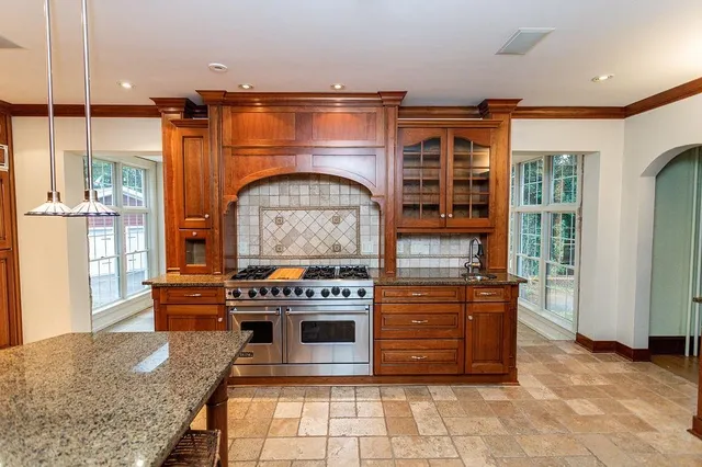 a kitchen with stainless steel appliances granite countertop a stove a sink and a microwave