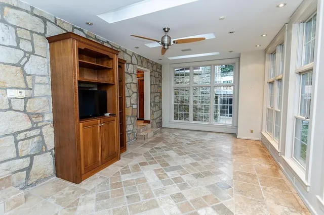 a view of an empty room with window and wooden floor