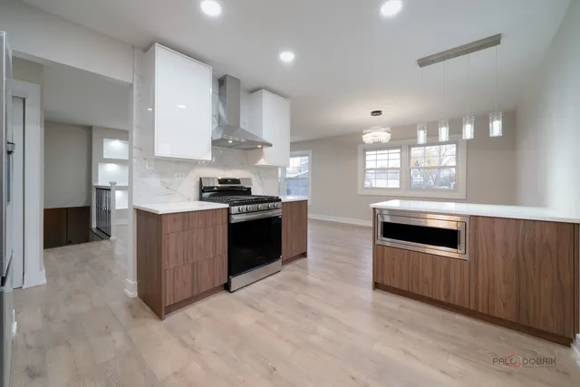 a kitchen with stainless steel appliances granite countertop a stove a sink and a refrigerator