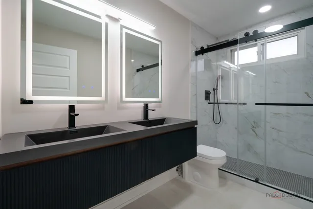 a bathroom with a double vanity sink toilet and shower
