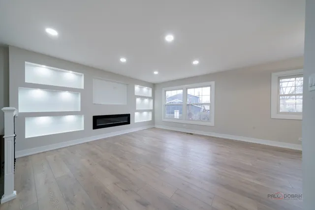 an empty room with wooden floor and fireplace