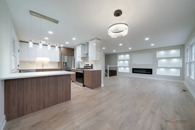a view of kitchen with kitchen island stainless steel appliances sink and cabinets