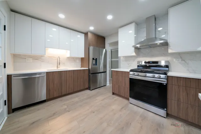 a kitchen with stainless steel appliances kitchen island granite countertop a stove a sink and a refrigerator