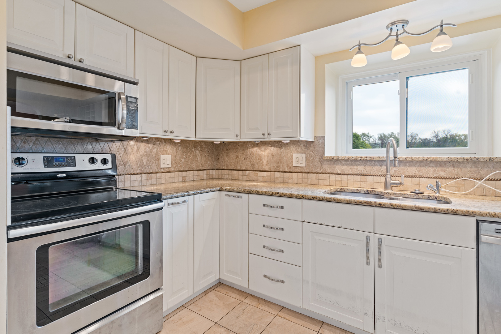 11130 NW Road, Unit E Palos Hills, IL 60465 - Photo 6 of 26 a kitchen with granite countertop white cabinets stainless steel appliances and a sink