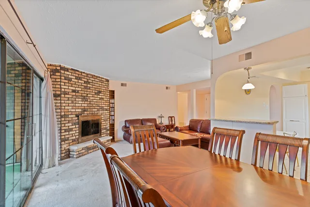 a dining room with furniture a chandelier and wooden floor