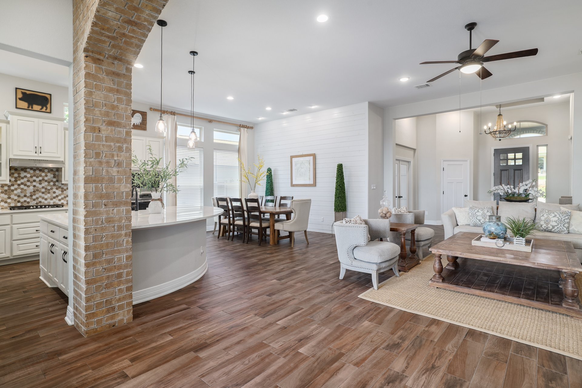 309 Rancho Sienna Loop Georgetown, TX 78628 - Photo 11 of 40 Open-concept living area with wood-finish flooring, a brick archway, and recessed lighting