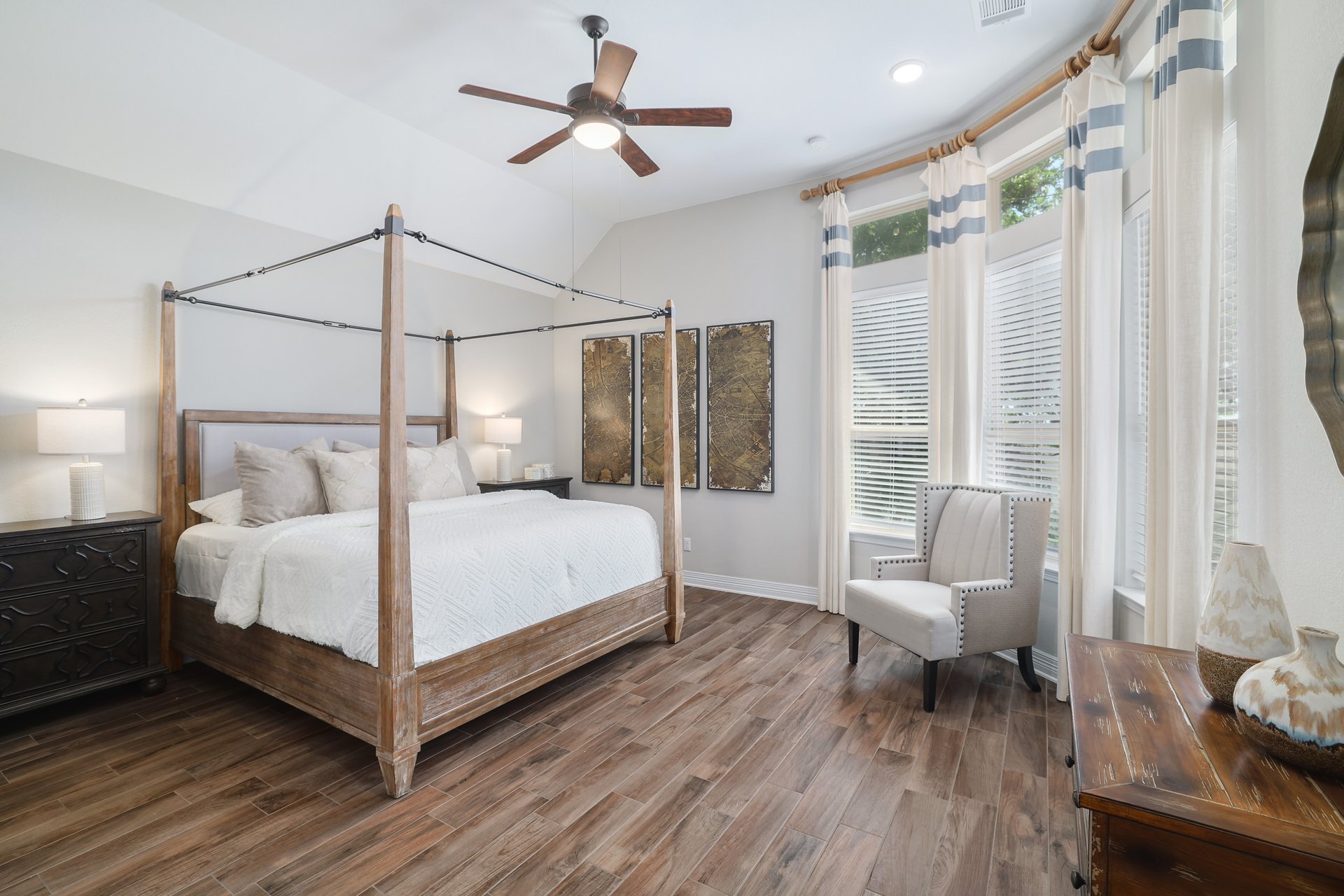 309 Rancho Sienna Loop Georgetown, TX 78628 - Photo 20 of 40 Vaulted ceiling bedroom featuring wood-finish flooring, a ceiling fan with integrated lighting, and a prominent bay window with multiple vertical blinds