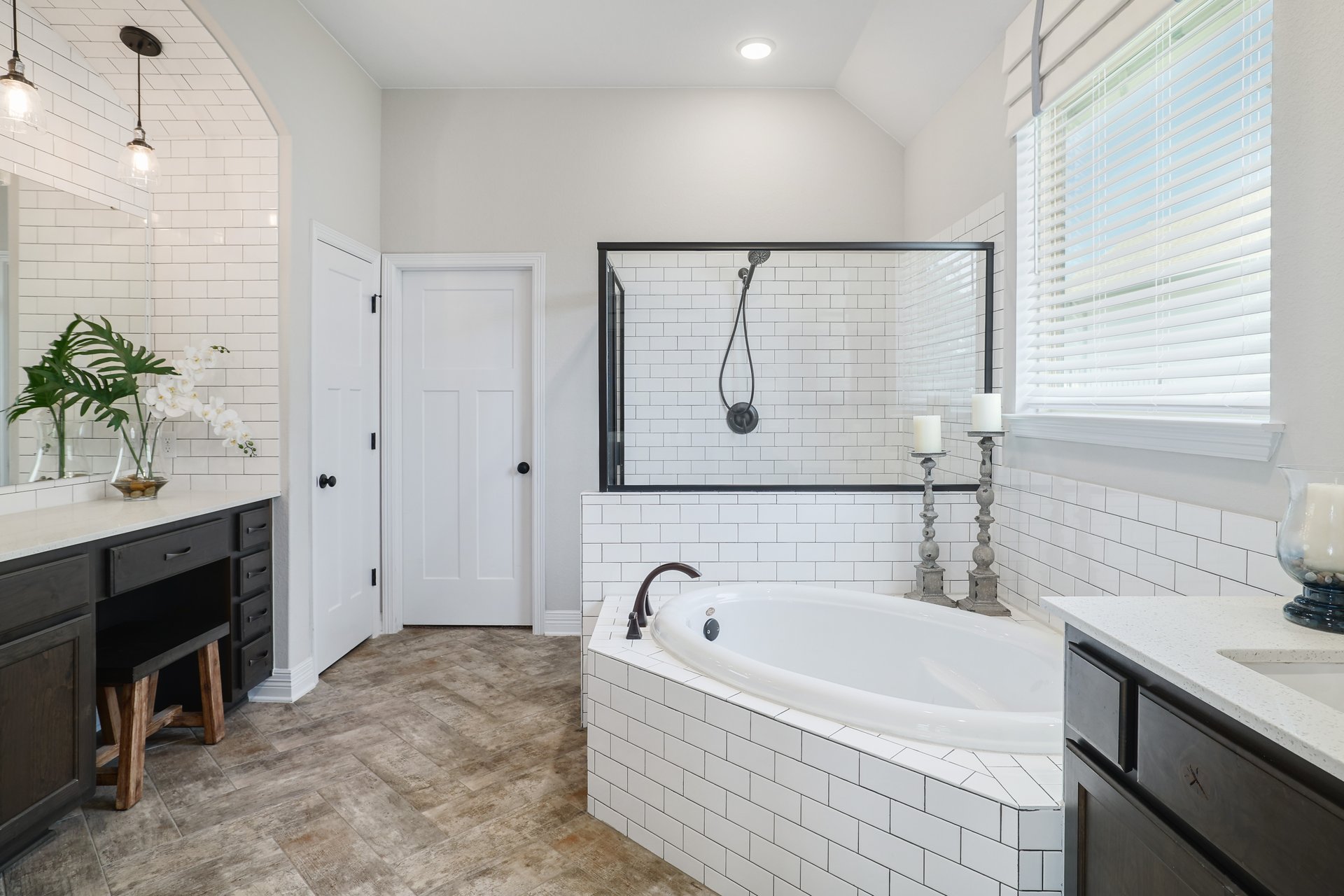 309 Rancho Sienna Loop Georgetown, TX 78628 - Photo 22 of 40 Bathroom featuring a built-in soaking tub, a separate glass-enclosed shower with subway tile surround, and a double vanity with stone countertops