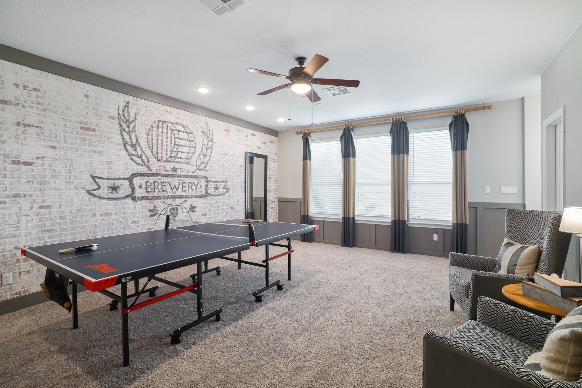 309 Rancho Sienna Loop Georgetown, TX 78628 - Photo 29 of 40 Spacious bonus room featuring a decorative brick accent wall, plush carpet flooring, a ceiling fan with integrated lighting, and multiple windows with paneling below