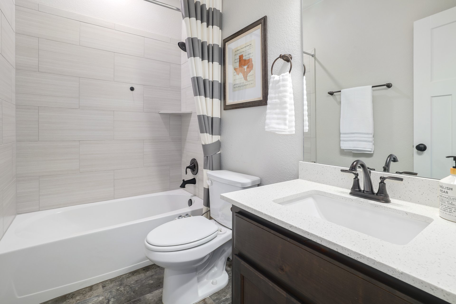 309 Rancho Sienna Loop Georgetown, TX 78628 - Photo 31 of 40 Bathroom featuring a white bathtub with subway tile surround and dark bronze fixtures