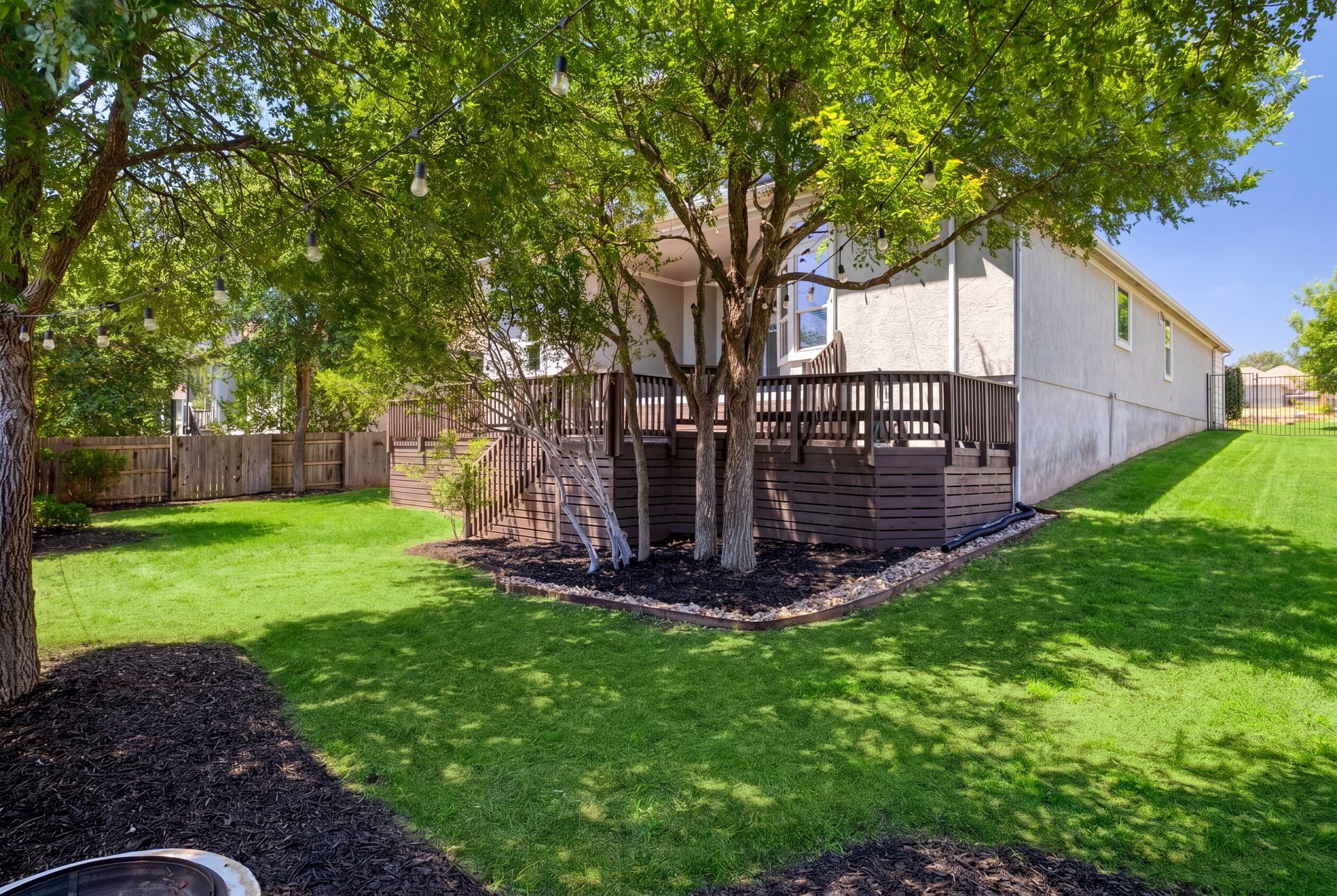 309 Rancho Sienna Loop Georgetown, TX 78628 - Photo 37 of 40 Spacious backyard featuring a multi-level wood deck, mature trees, and a sloped lawn