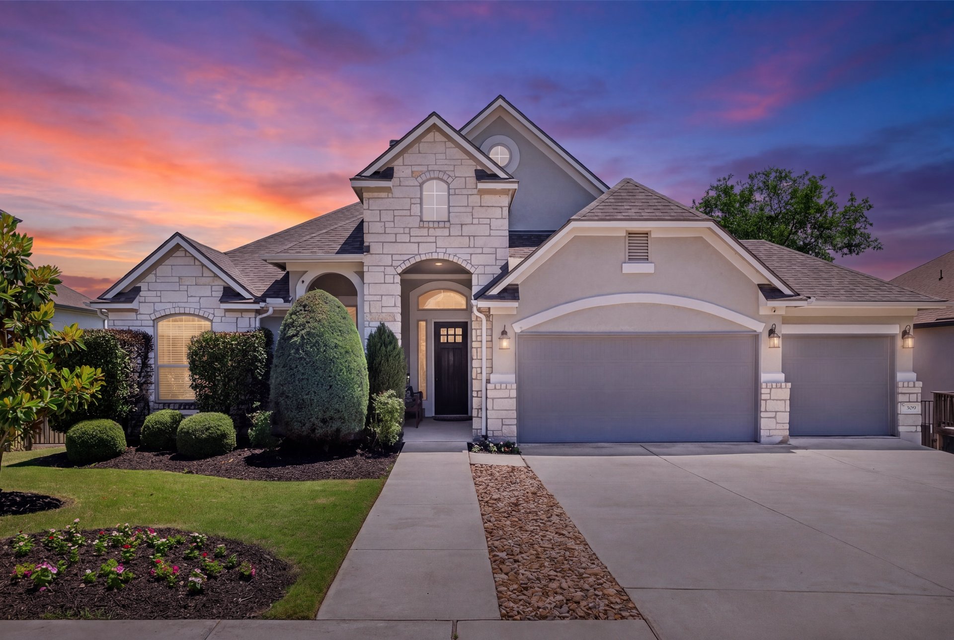 309 Rancho Sienna Loop Georgetown, TX 78628 - Photo 40 of 40 Stone and stucco exterior featuring a dark wood front door, arched entryway, and multiple gables