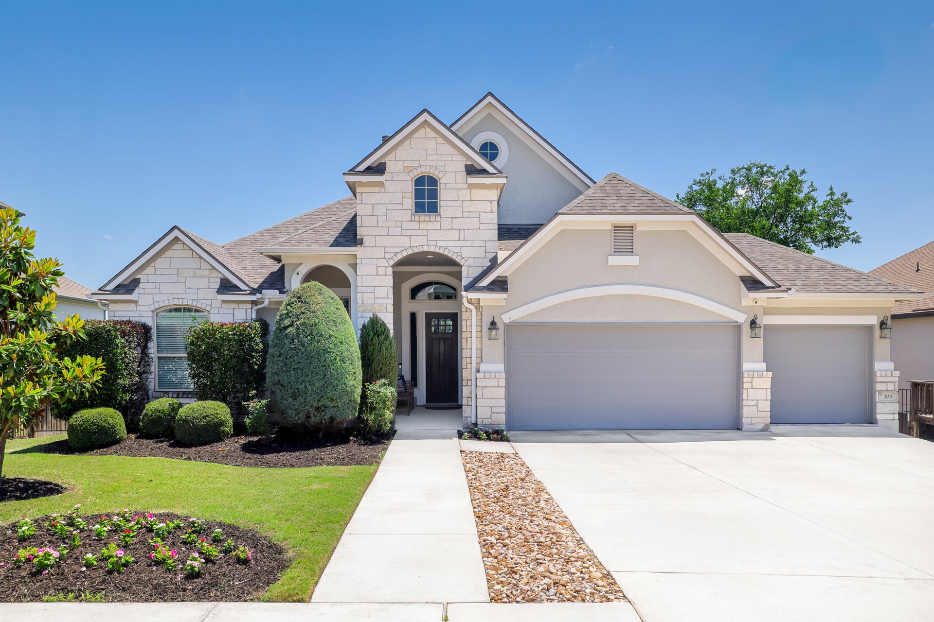309 Rancho Sienna Loop Georgetown, TX 78628 - Photo 4 of 40 Stone and stucco exterior with multiple gables and a prominent arched entry