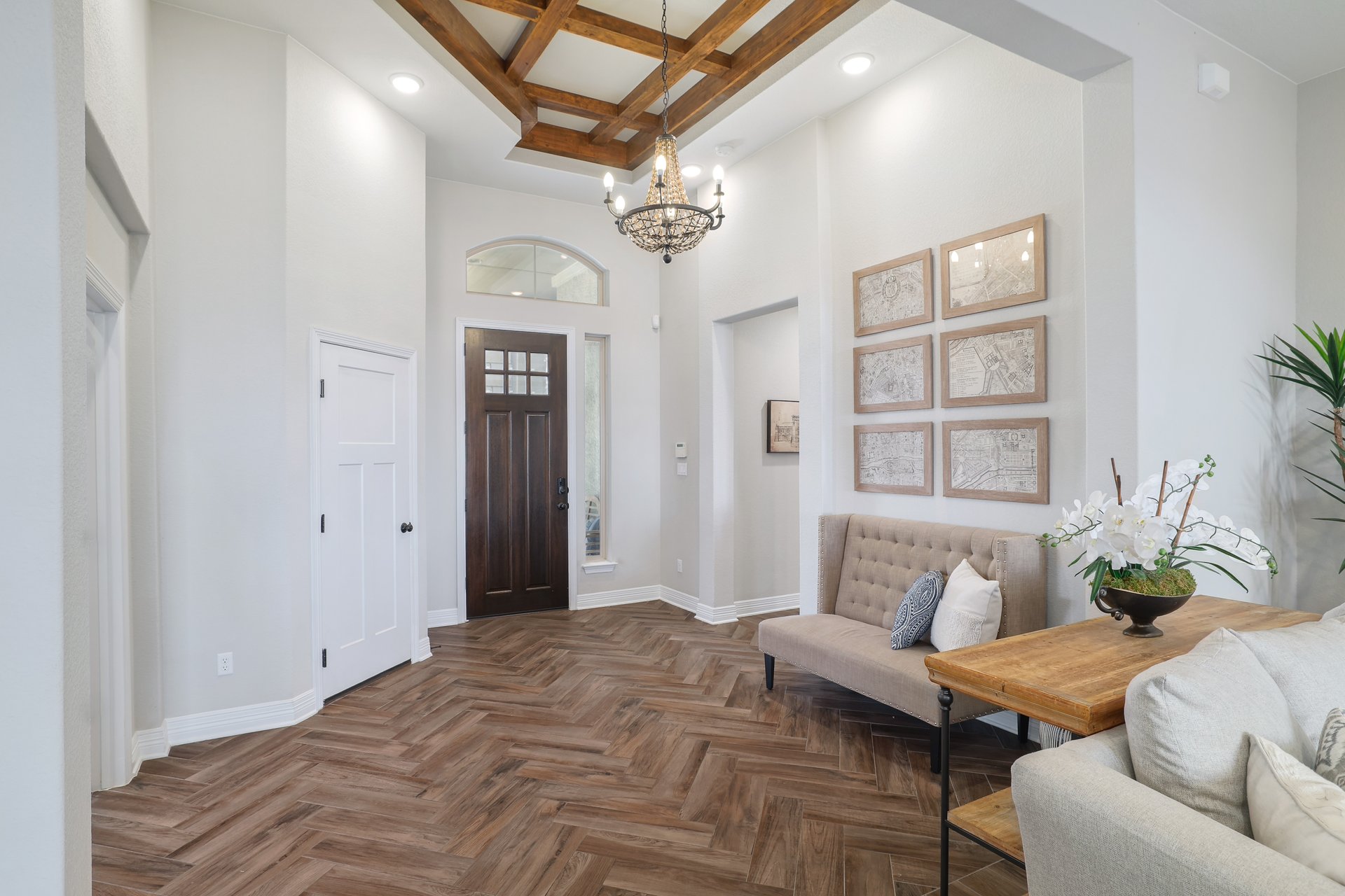 309 Rancho Sienna Loop Georgetown, TX 78628 - Photo 7 of 40 Grand entryway featuring wood-finish herringbone flooring, a coffered ceiling with wood beams, a chandelier, and a solid wood front door with glass panels and an arched transom window