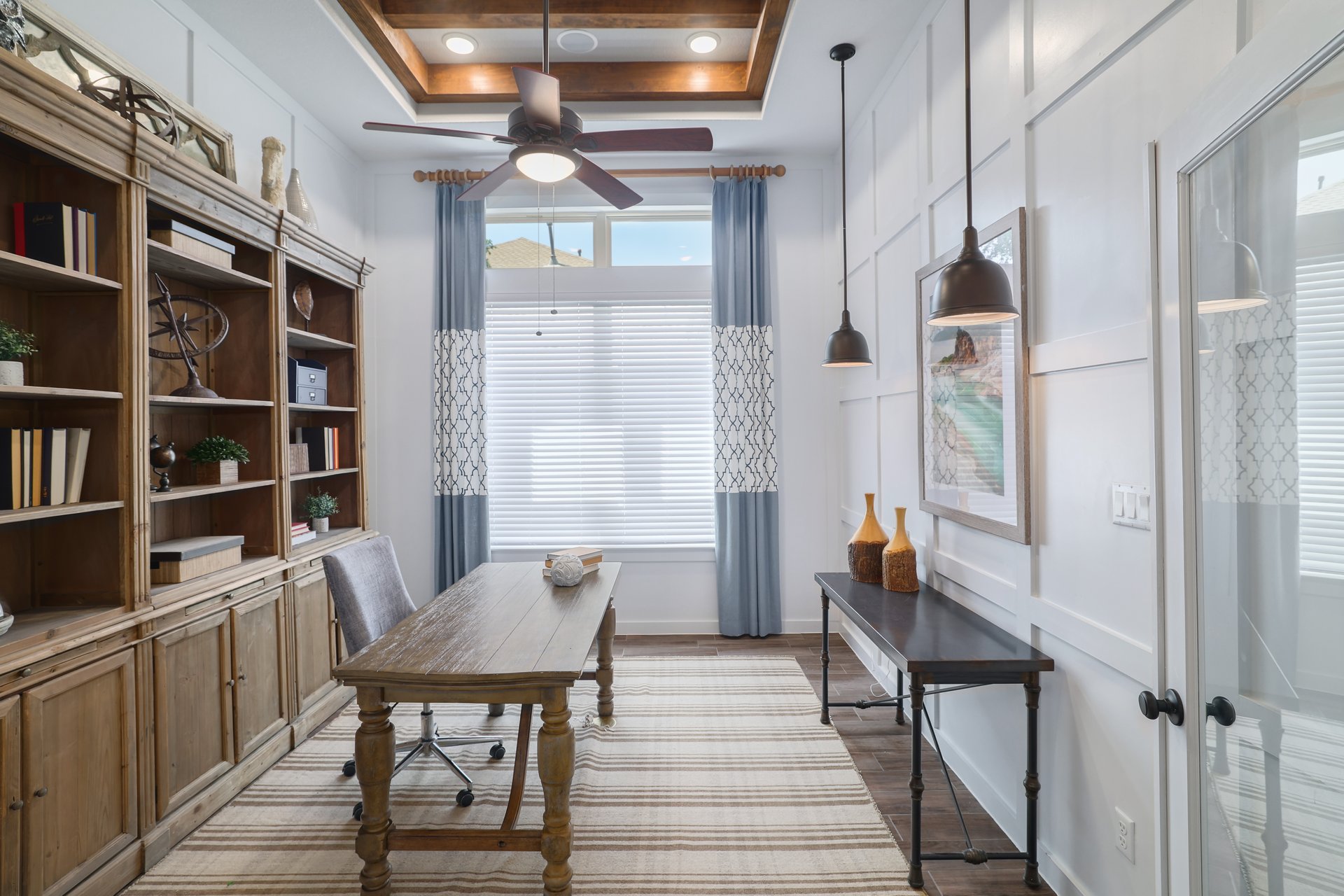 309 Rancho Sienna Loop Georgetown, TX 78628 - Photo 9 of 40 Dedicated workspace featuring a coffered wood-beam ceiling, ceiling fan, and built-in shelving with lower cabinetry