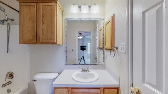 a bathroom with a sink a toilet and shower curtain