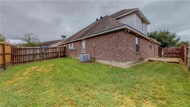a view of backyard of house with wooden fence