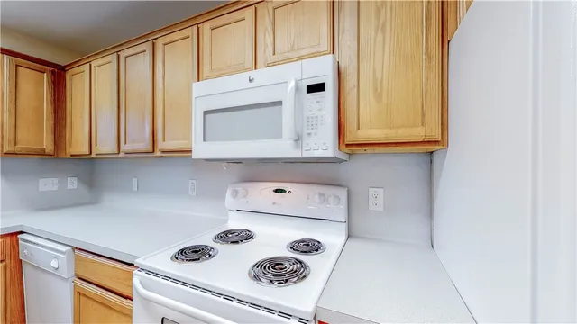 a kitchen with white cabinets and white appliances