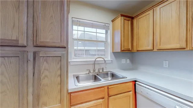 a kitchen with stainless steel appliances granite countertop white cabinets and a sink