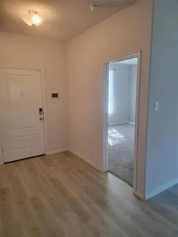 an empty room with wooden door and mirror
