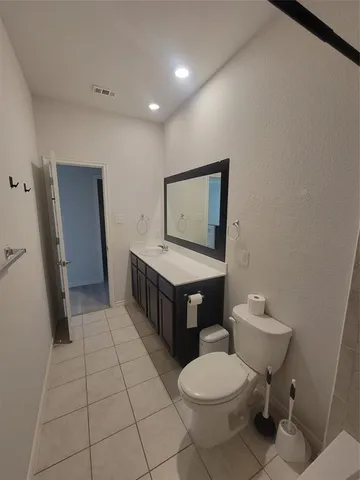 a bathroom with a toilet a sink a mirror and vanity