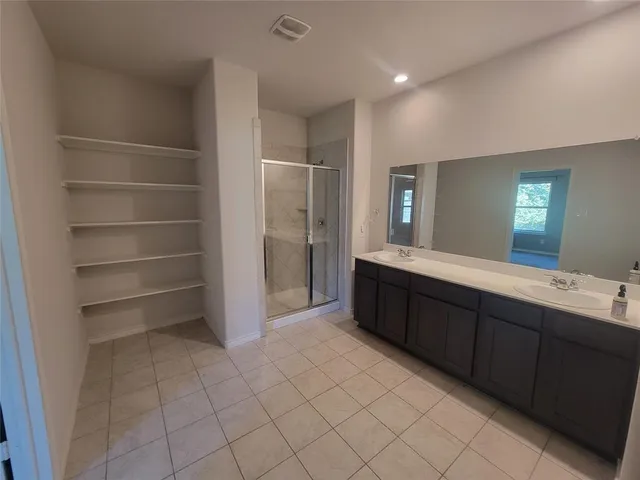 a spacious bathroom with a double vanity sink and a mirror