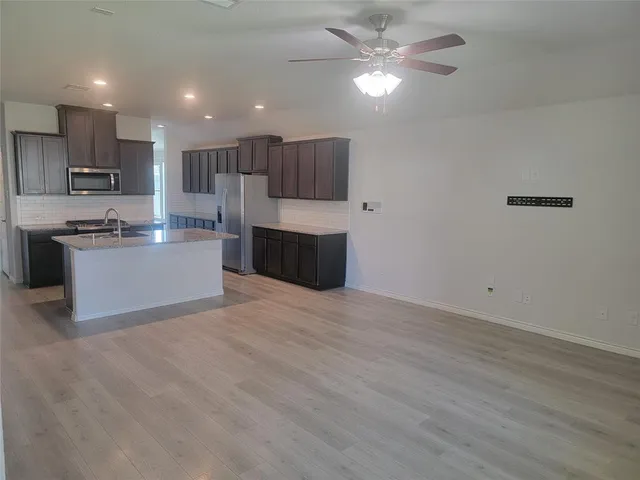 a kitchen with kitchen island a stove a sink and a refrigerator