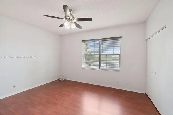 an empty room with a window and a fan