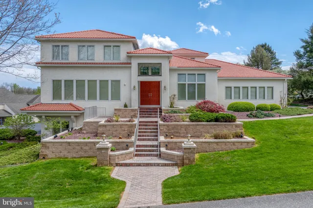 a front view of a house with a garden and fountain
