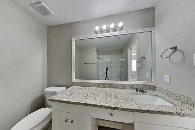a bathroom with a granite countertop sink and a mirror