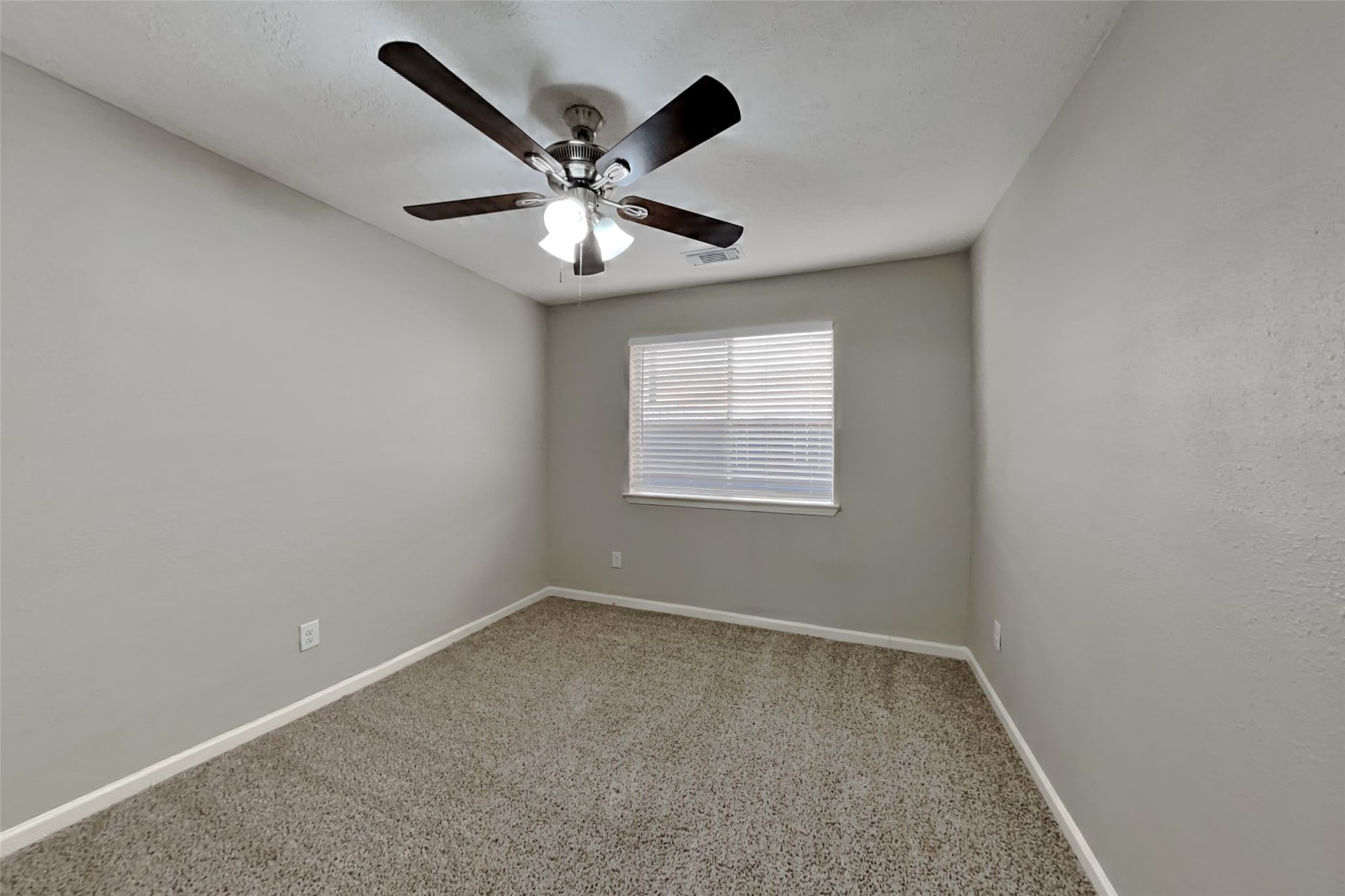 2217 Clemson Drive Katy, TX 77493 - Photo 13 of 18 an empty room with a chandelier fan and windows