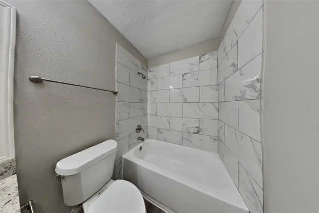 a bathroom with a toilet and bathtub