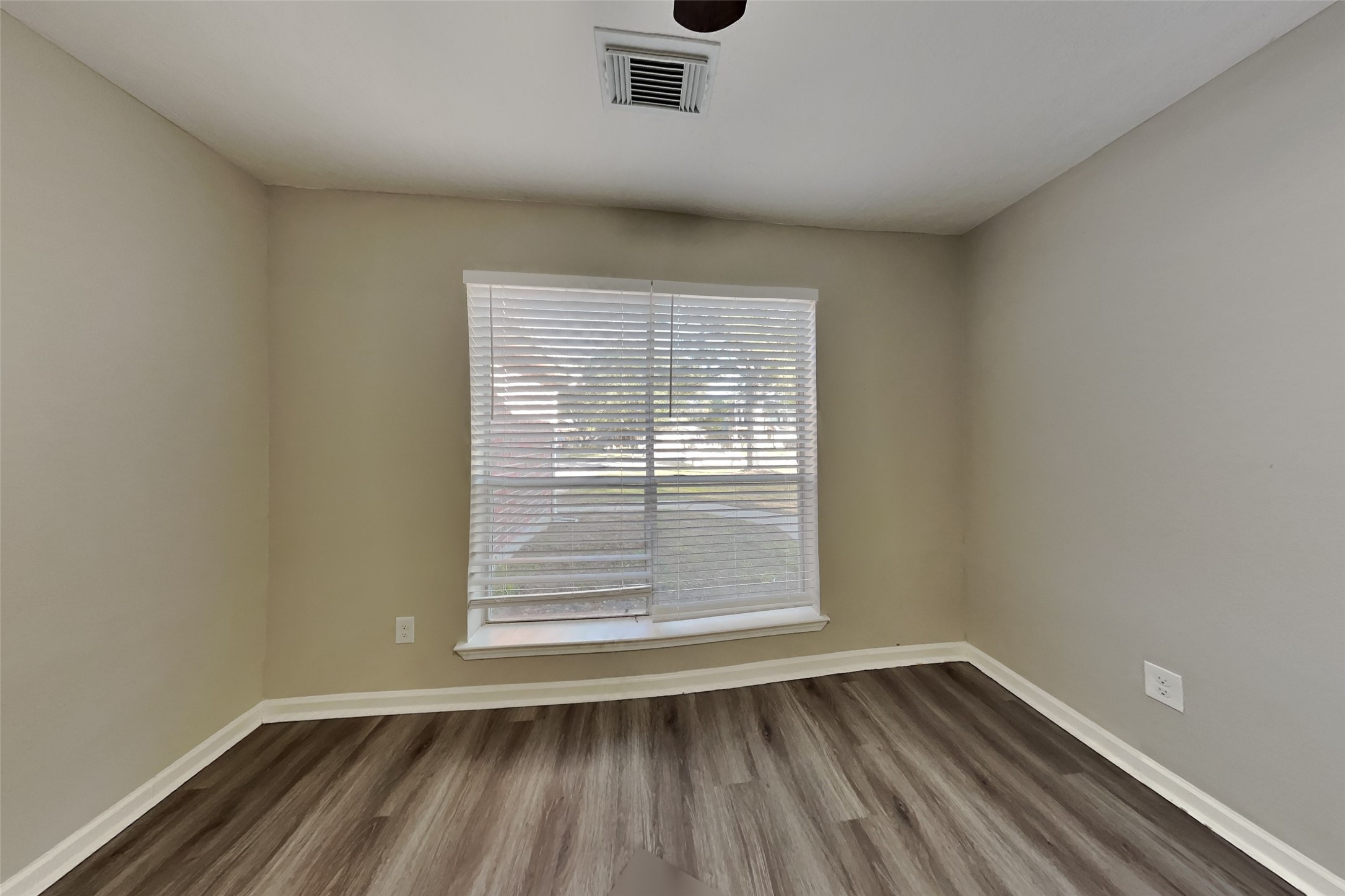 2217 Clemson Drive Katy, TX 77493 - Photo 16 of 18 a view of an empty room with wooden floor and a window