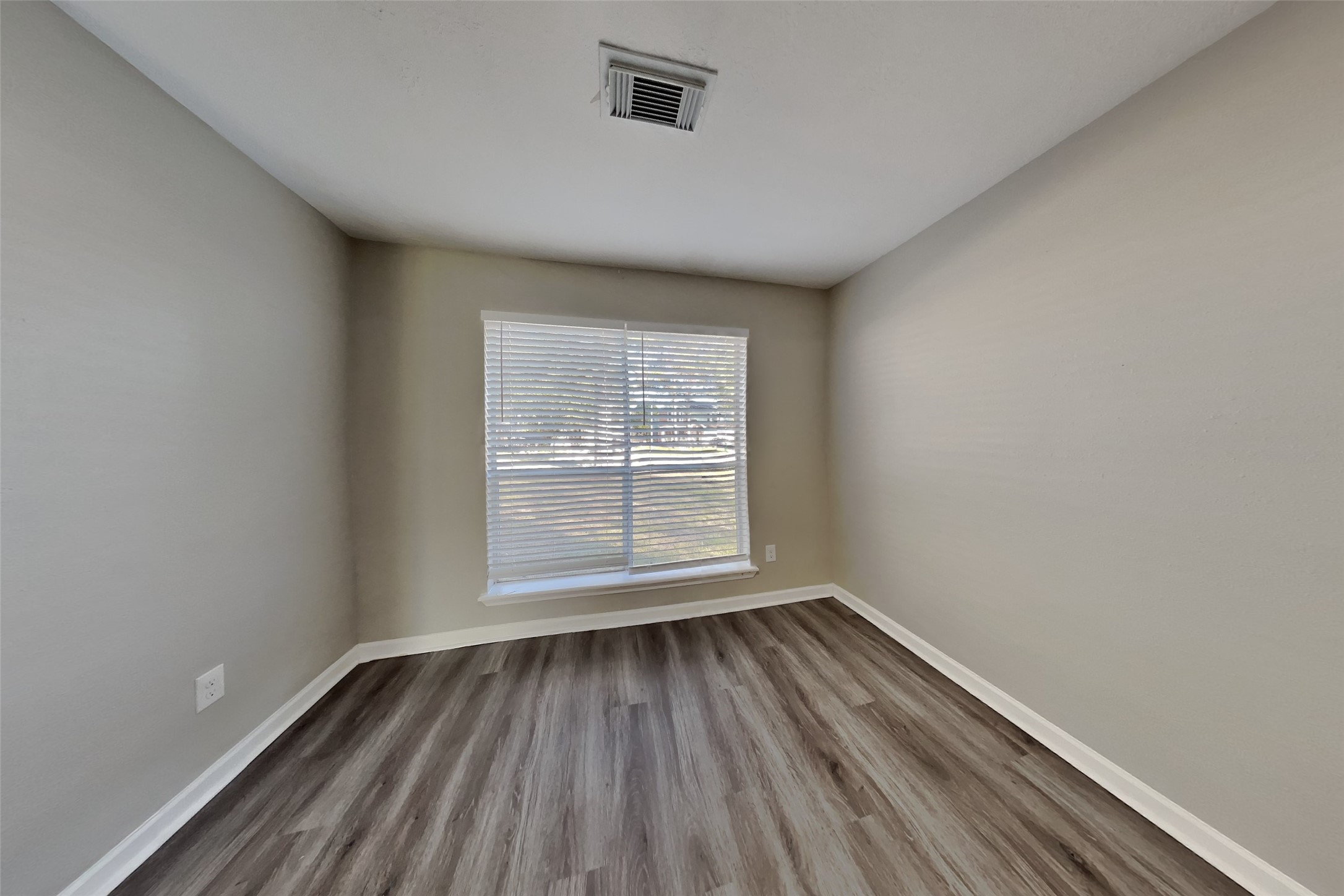 2217 Clemson Drive Katy, TX 77493 - Photo 2 of 18 an empty room with wooden floor and windows