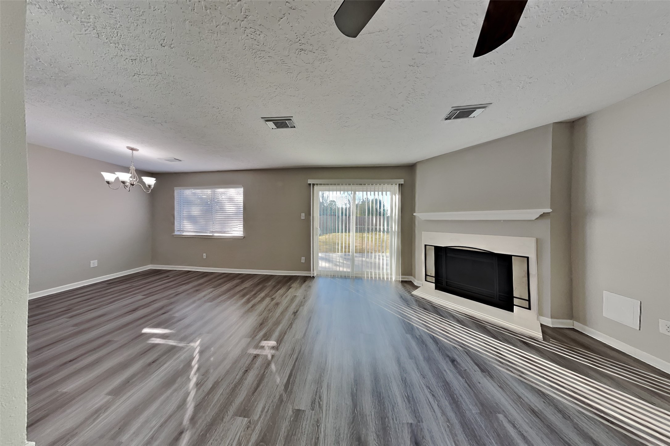 2217 Clemson Drive Katy, TX 77493 - Photo 4 of 18 a view of an empty room with wooden floor fireplace and a window
