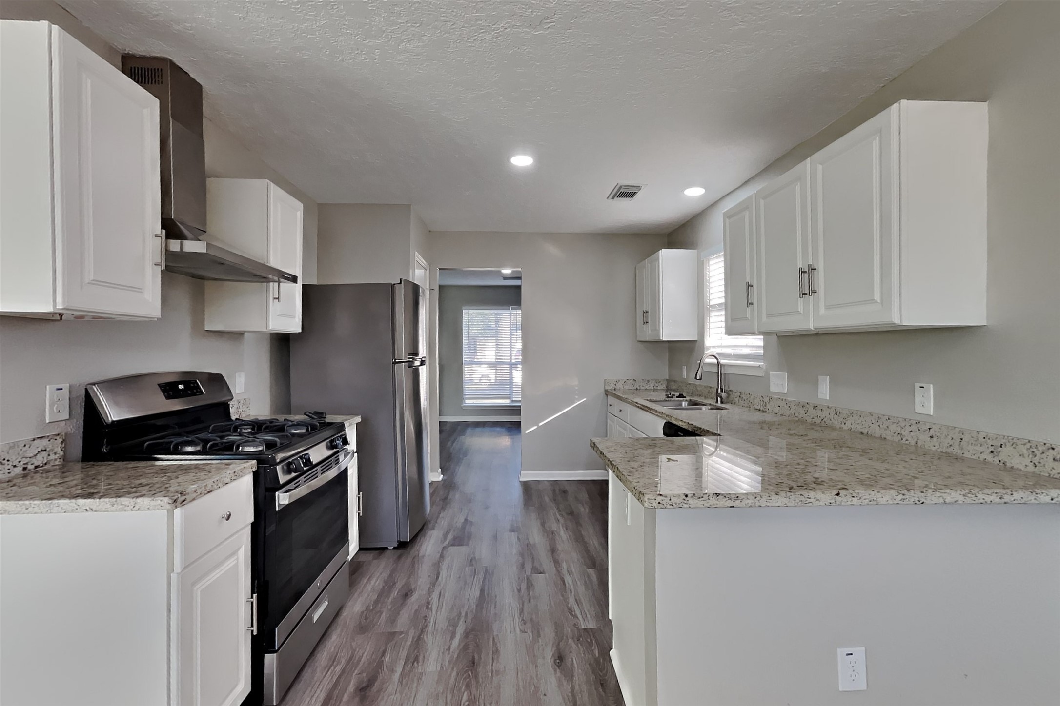 2217 Clemson Drive Katy, TX 77493 - Photo 6 of 18 a kitchen with stainless steel appliances granite countertop a stove a sink and a refrigerator