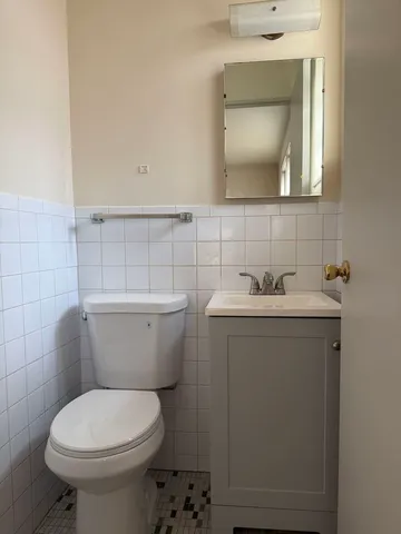 a bathroom with a toilet sink and mirror