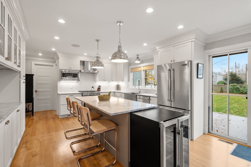 106 Jefferson Street Dedham, MA 02026 - Photo 15 of 42 a kitchen with stainless steel appliances granite countertop a refrigerator a sink dishwasher a stove and a dining table with wooden floor