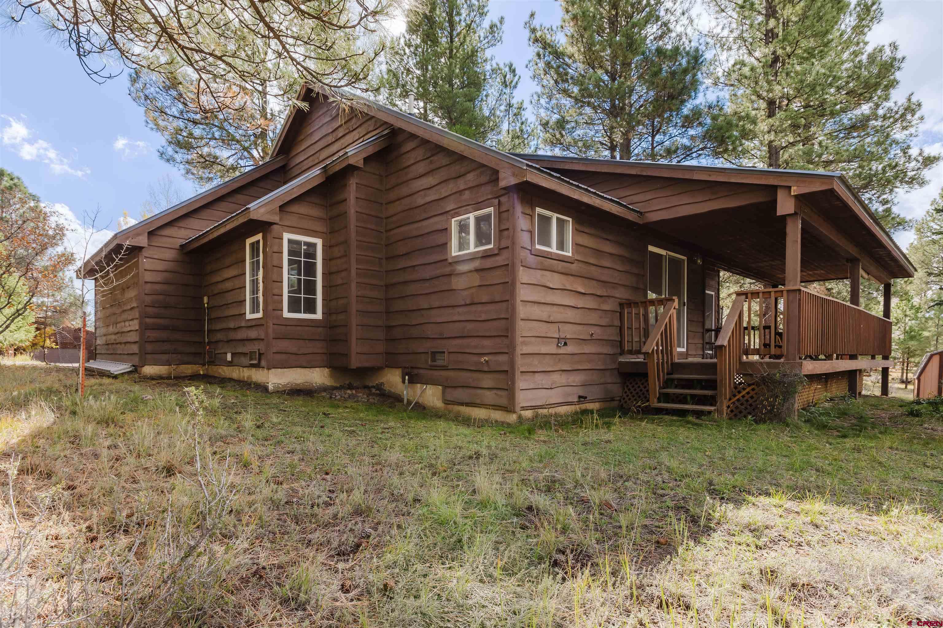 285 Beaver Circle Pagosa Springs, CO 81147 - Photo 12 of 42 a backyard of a house with barbeque oven and yard