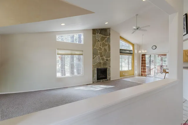 a view of an empty room with a fireplace and a window