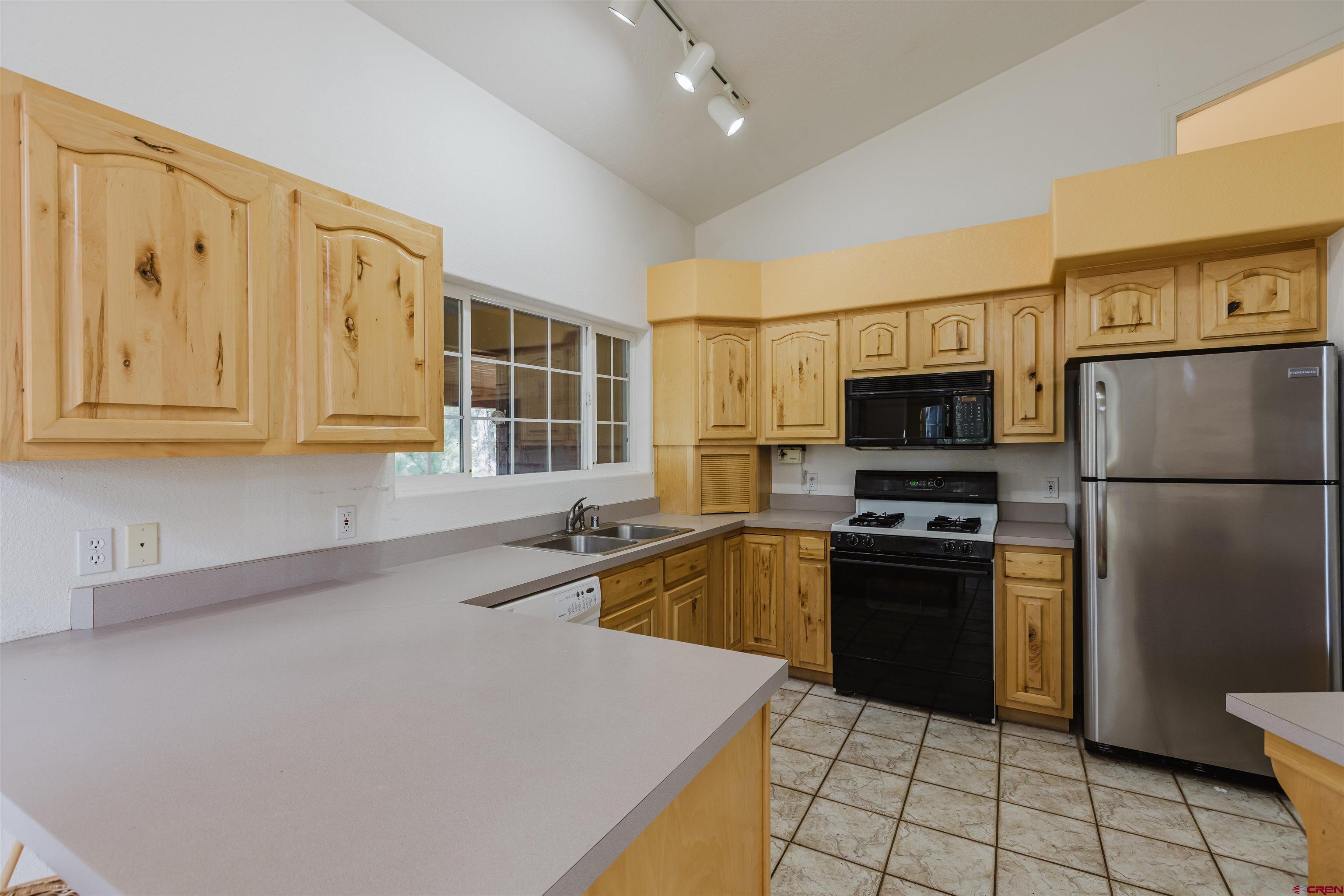 285 Beaver Circle Pagosa Springs, CO 81147 - Photo 22 of 42 a kitchen with stainless steel appliances granite countertop a refrigerator sink and stove