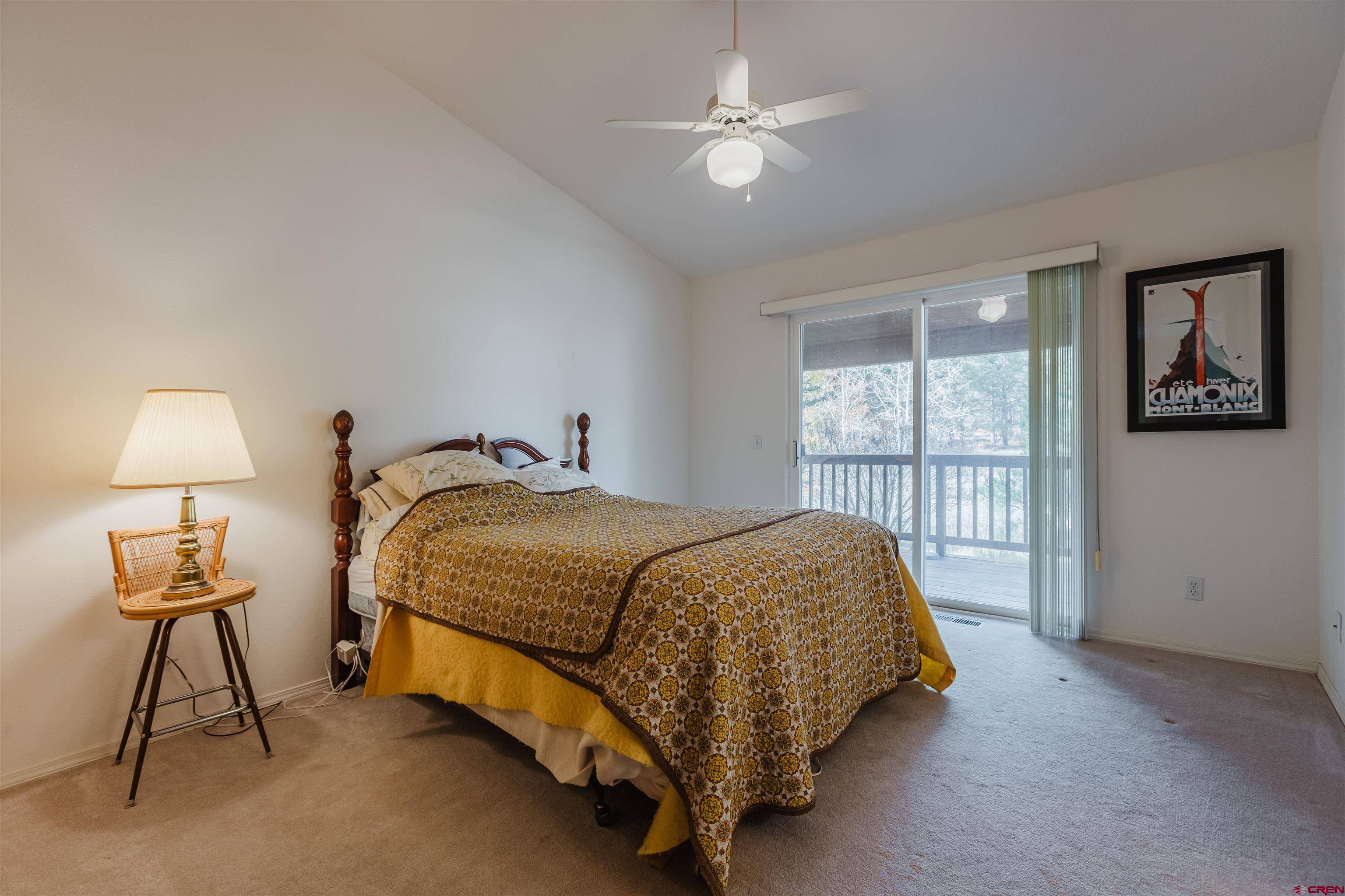 285 Beaver Circle Pagosa Springs, CO 81147 - Photo 25 of 42 a spacious bedroom with a bed and a lamp